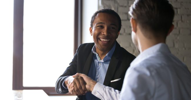 Satisfied black client shaking hands thanking manager for good d