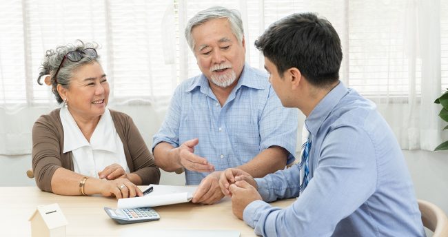Retired couple talking with agent about contract agreement